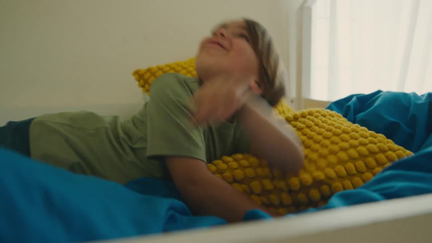 A child smiles while laying in bed