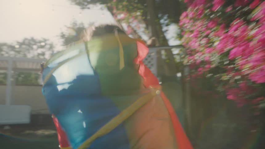 Children running inside bags of toys through the backyard of a house