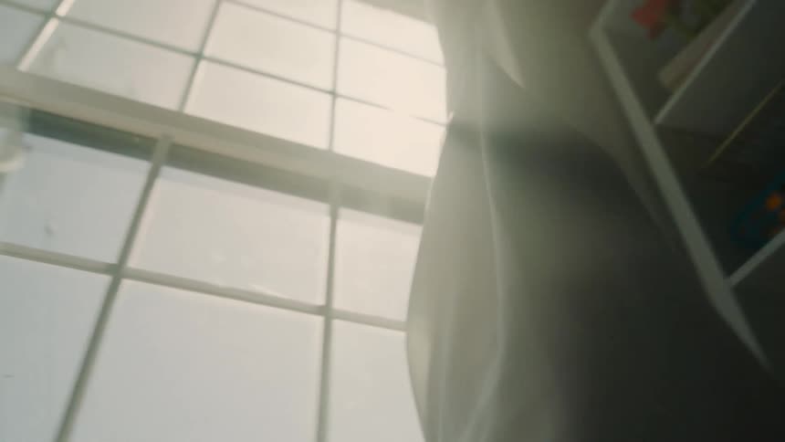 Two children getting tangled up in a window curtain