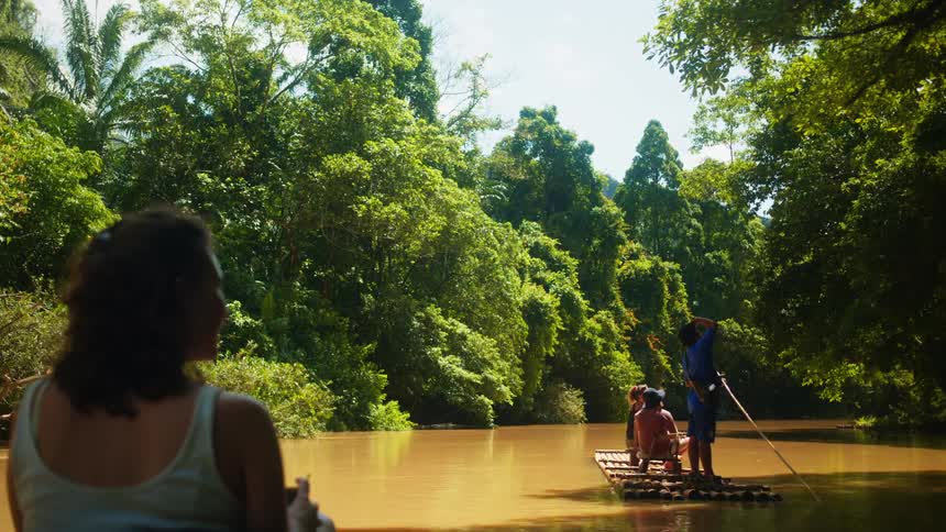 People are traveling on flat wooden rafts in the river