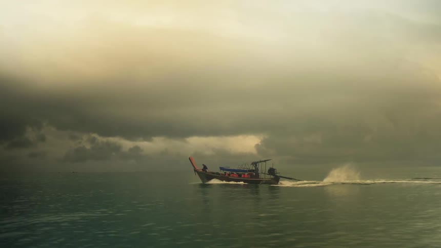 The boat moves fast in the ocean on a cloudy day