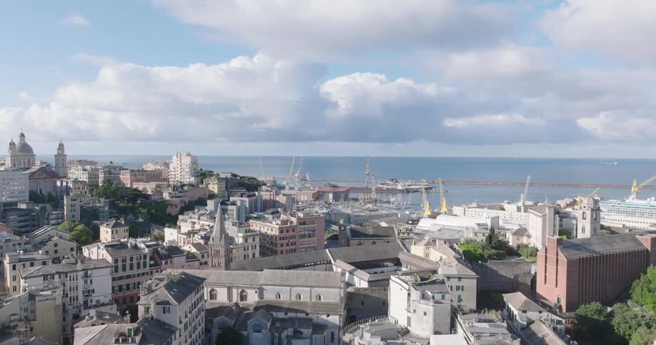 The densely packed buildings of genoa italy stretching towards the ligurian sea under a partly cloudy sky