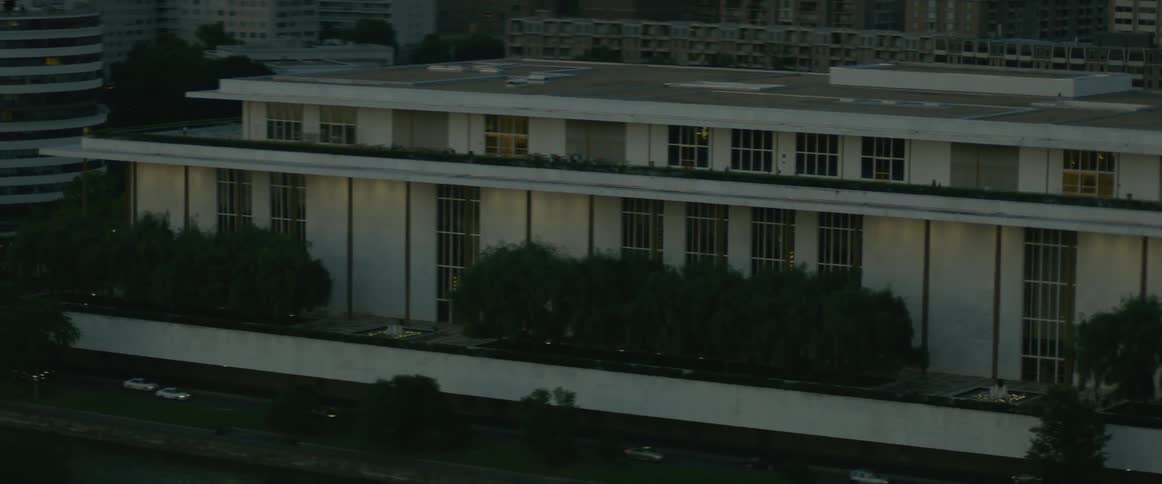 A large building has trees across the front