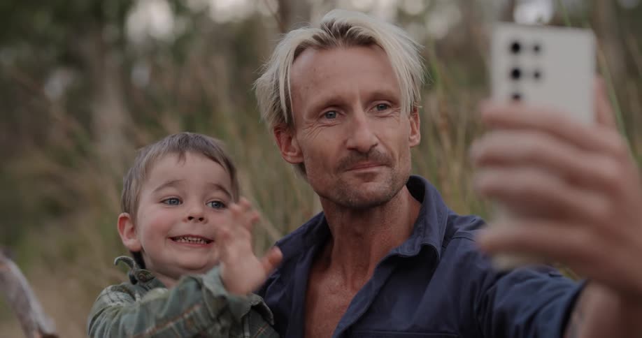A man and his son smile at the cellphone