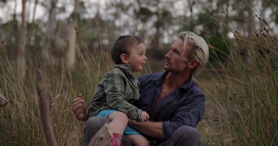 A man holding a child in his arms smiling and having fun together
