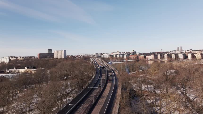 Traffic moves on a highway headed into a city