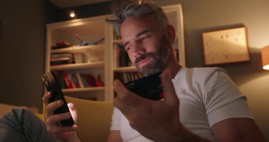 A man is typing his credit card into his phone to pay for something