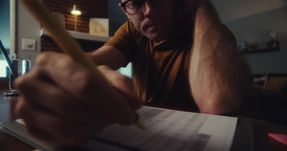Man with a pencil scribbling on a document