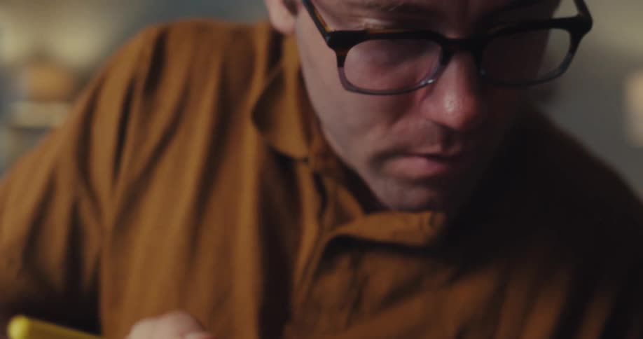Man in glasses with highlighter underlining a document