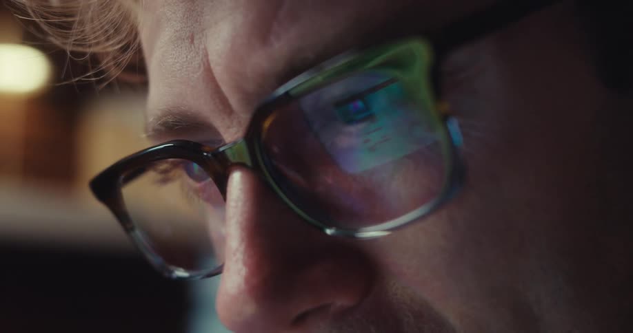 A man observing something through his glasses