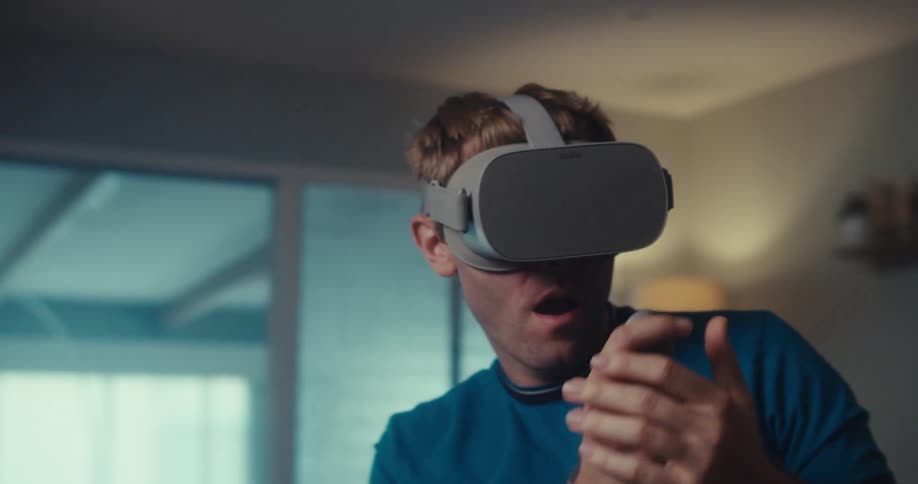 Man in a living room playing on virtual reality glasses