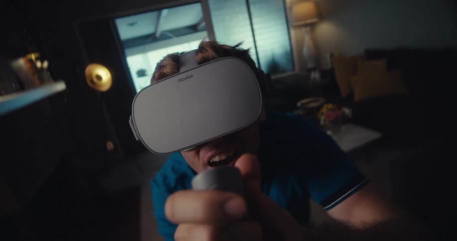 A man in a living room playing a virtual reality video game
