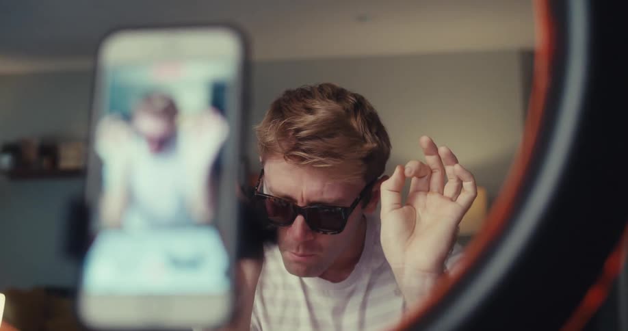 A man claps his hands and talks to the camera