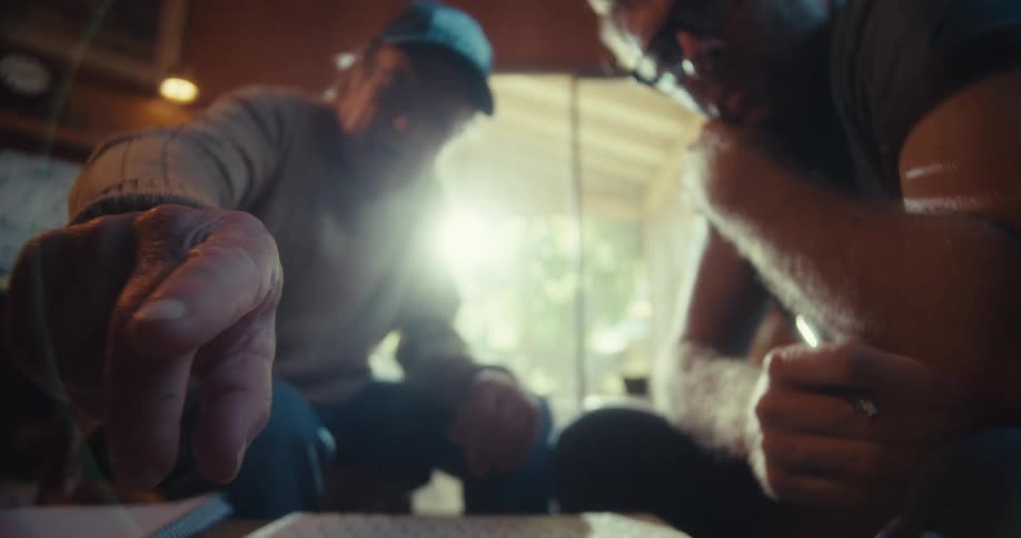 Man sitting talking to an elderly man who points in a direction
