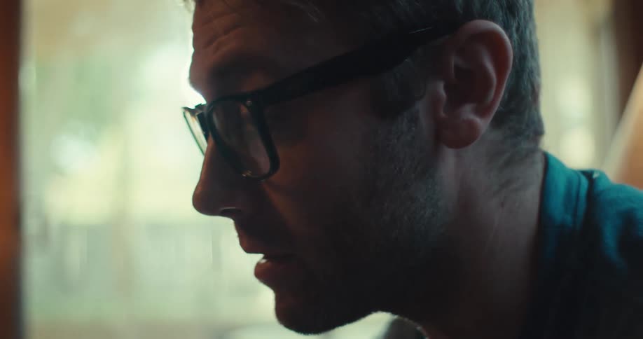 Man with glasses sitting and talking