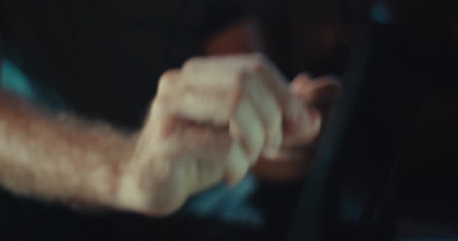 Man gesturing with one hand and holding glasses in another