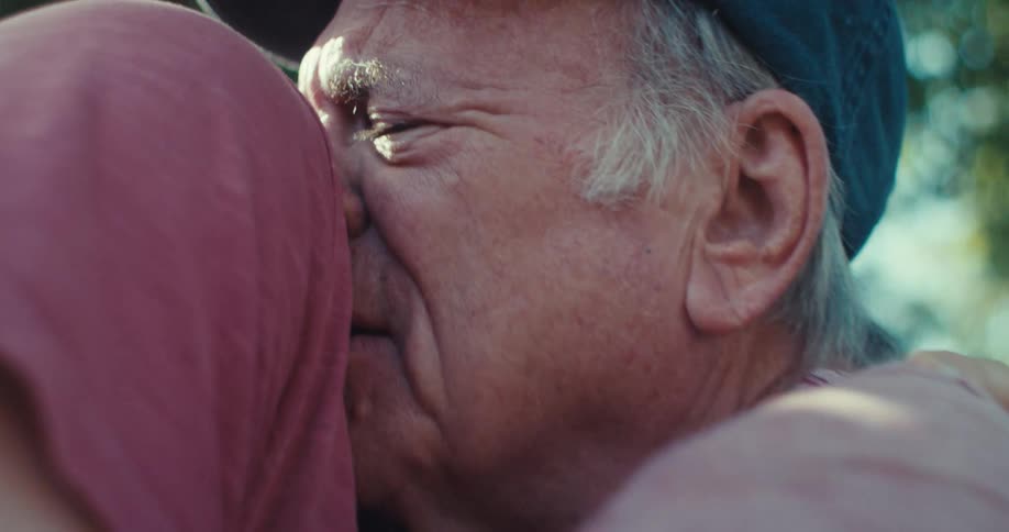 Young man hugging an elderly gentleman affectionately