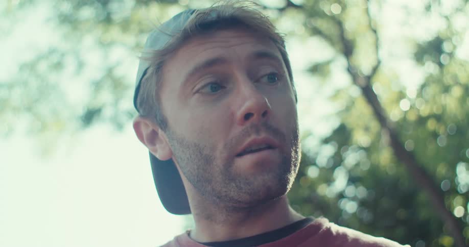 A close up footage of two men having a conversation while one of the men is tossing a tennis