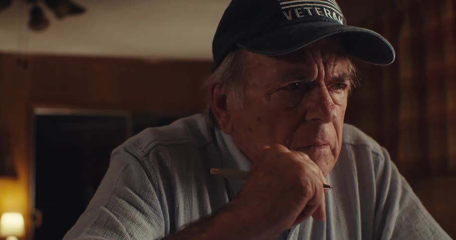 Veteran with concentrated expression holds a pen