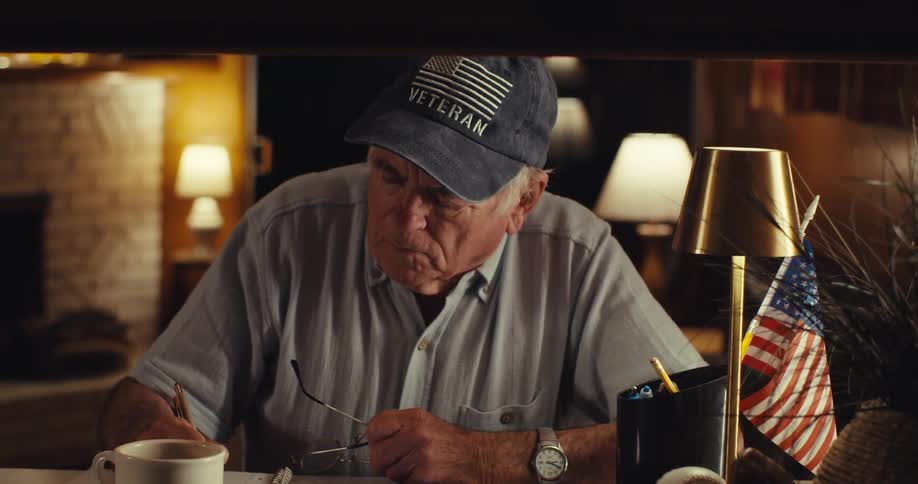 A man sits at a desk and writes