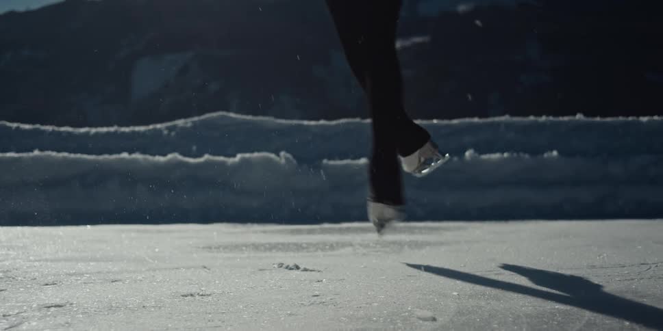 An ice skater jumps and twirls