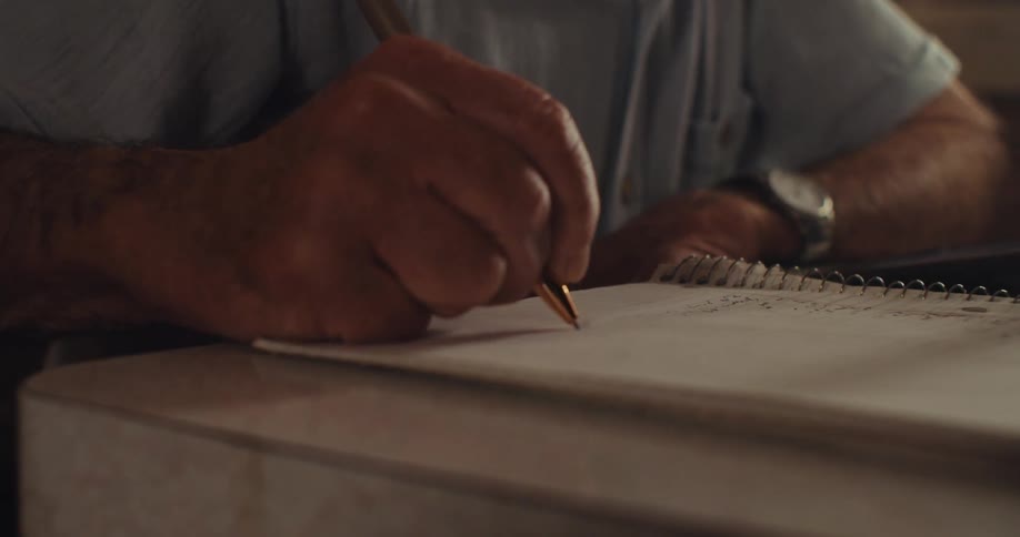 A man uses his tablet and writes in a notebook