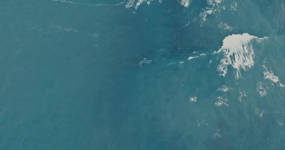 A large wave is moving across the surface of the ocean