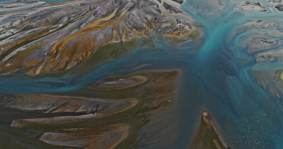 Turquoise glacial rivers wind between colorful rock formations