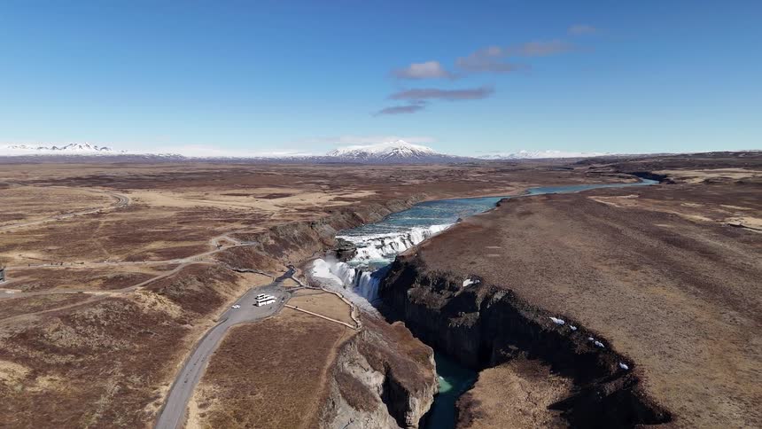 A large river cuts through the land ending in a waterfall