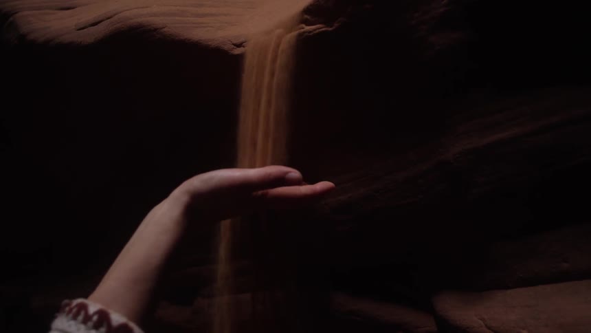 Brown dirt falls from the side of a canal wall