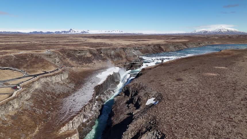 A large river cuts through the land ending in a waterfall