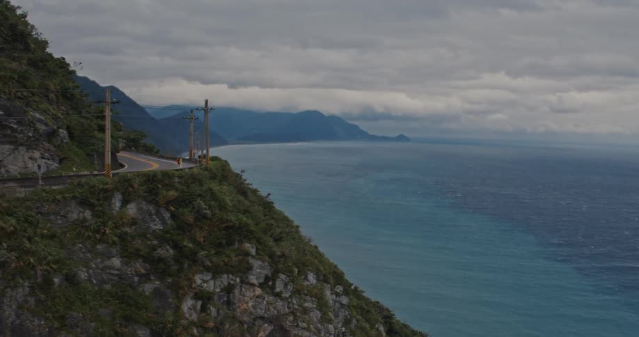 A road runs along a cliff by the ocean