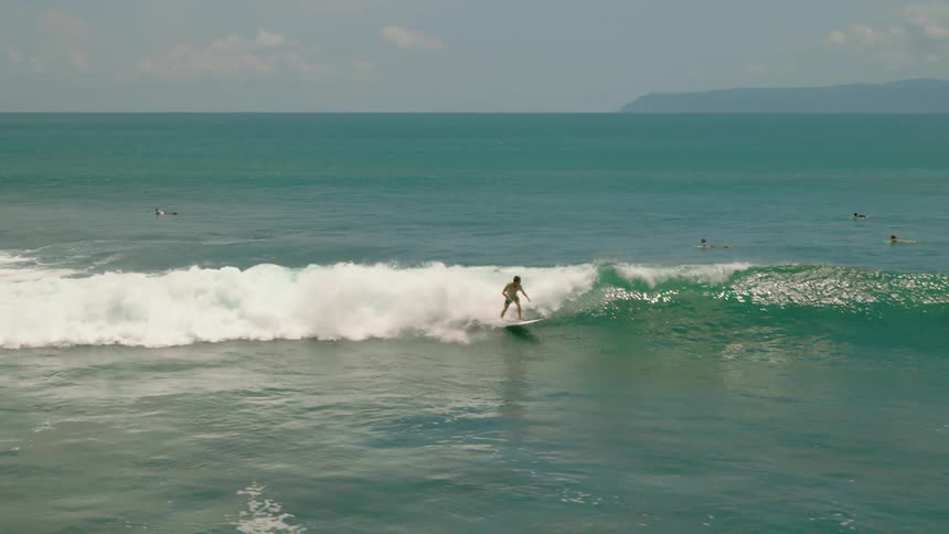 Surfer continuously rides onto a cresting wave until it smooths out