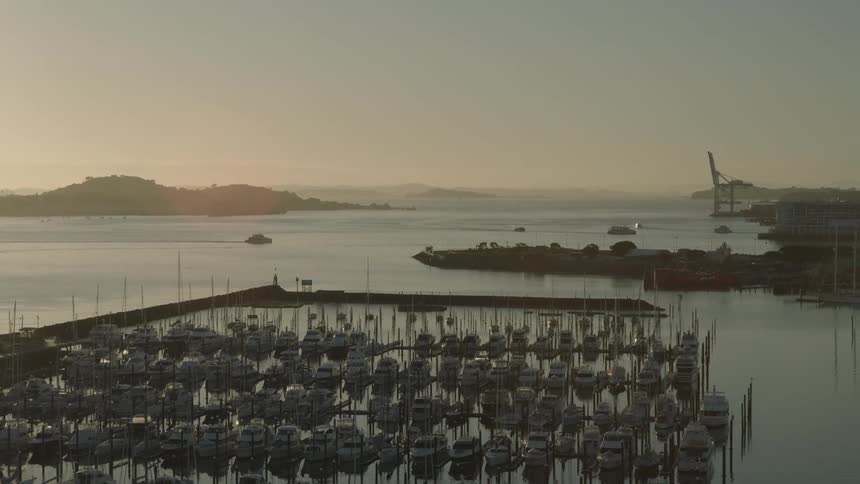 A port with many boats in a coastal city and other boats moving in the sea