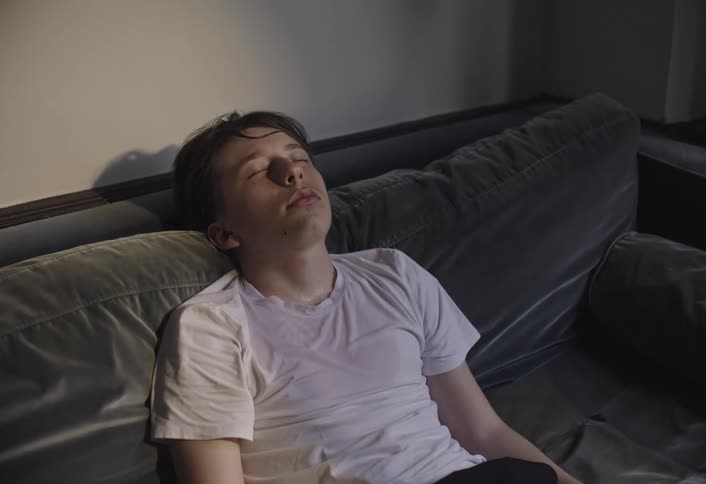 A man is sweating while resting on the couch