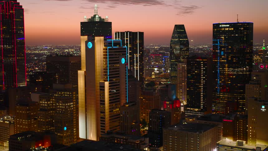 The illuminated skyline of dallas texas at dusk with various skyscrapers displaying distinct architectural designs and lighting