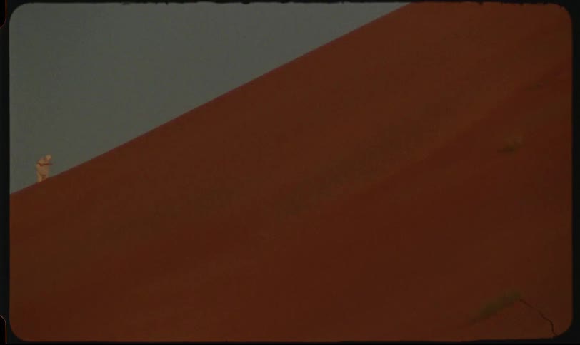 A person walking on a dune in the desert