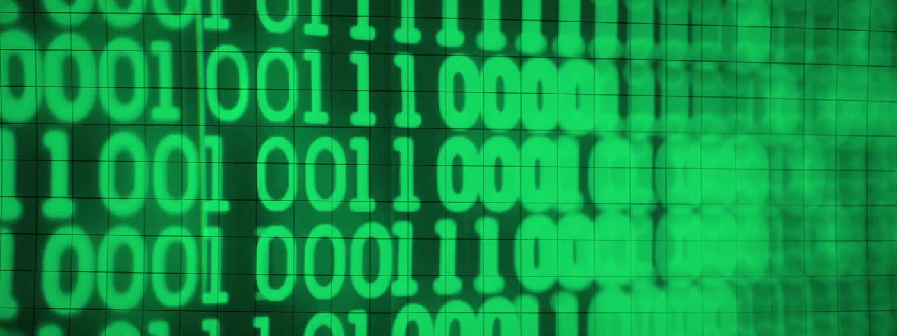 Green computer code appears on a grid pattern surface