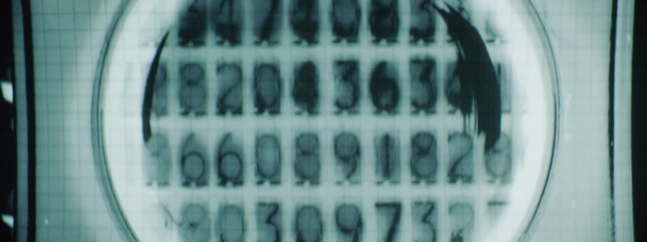 Numbers flash and count on the projection on the wall