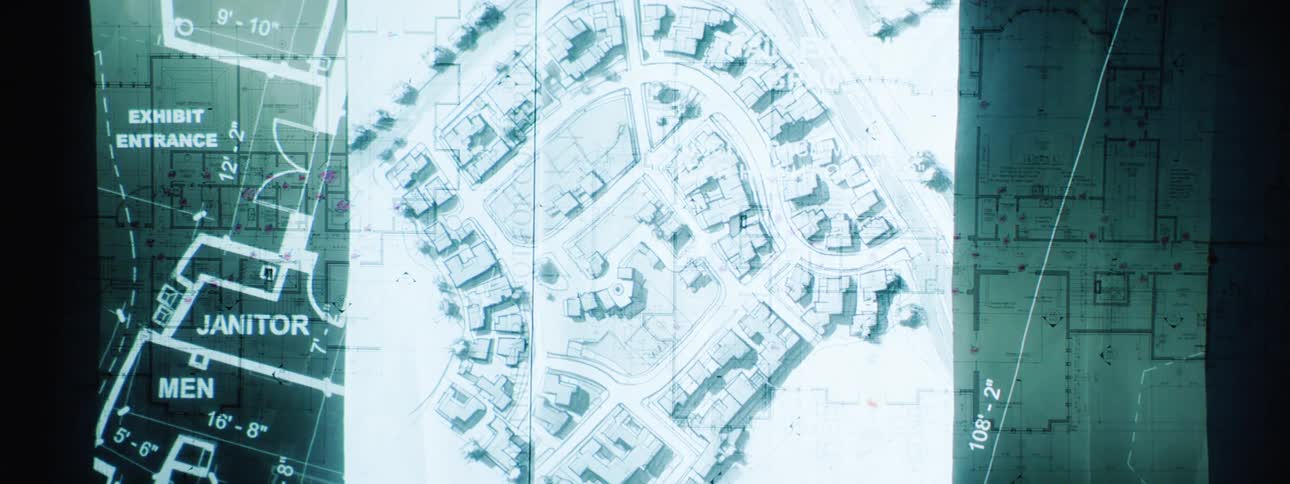 Overlapping architectural and urban planning blueprints display detailed building layouts dimensions and street grids