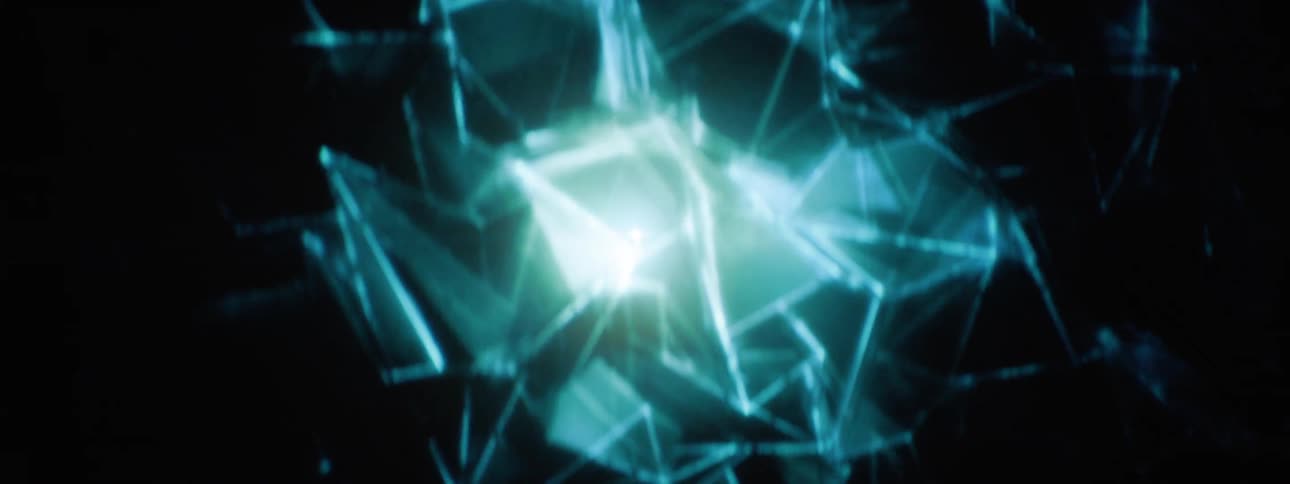 Glass shards float around a blue light