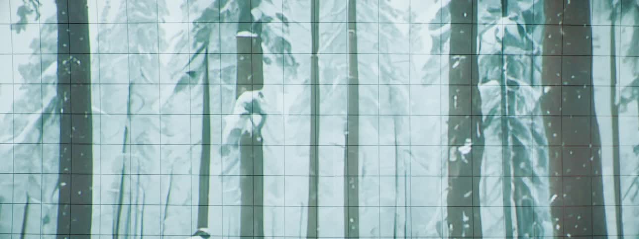 A large screen displaying an animation of trees in winter covered in snow