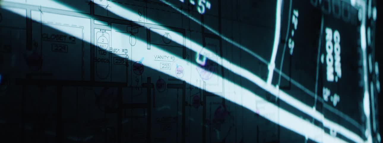 A projection is superimposed over a set of paper blueprints
