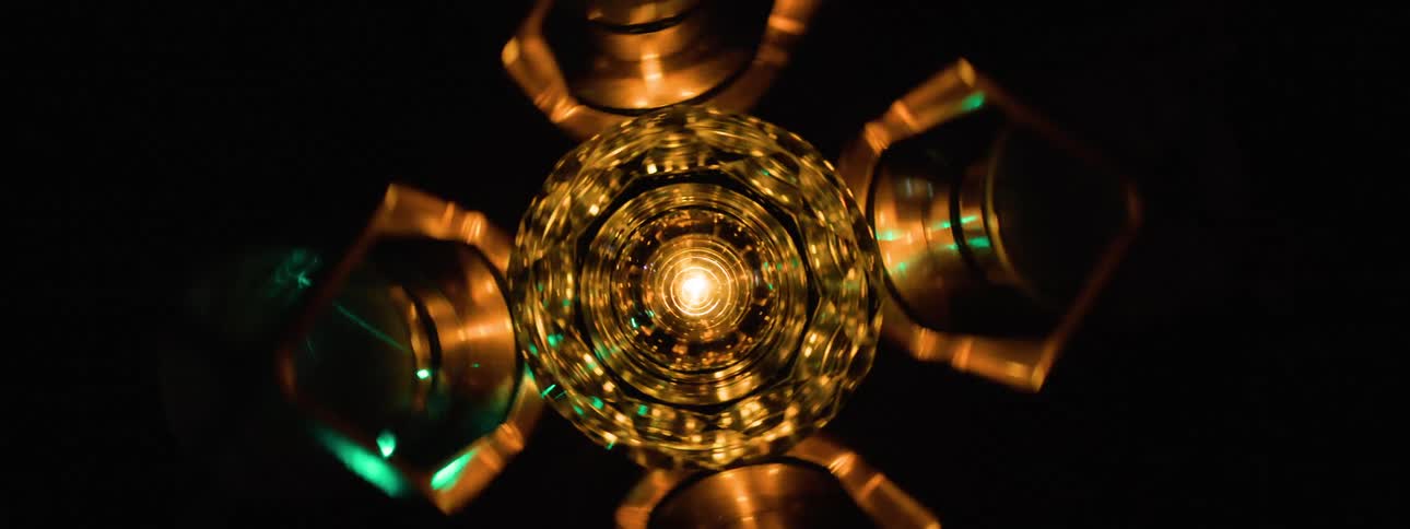 A metal object is spinning as lights flash on it
