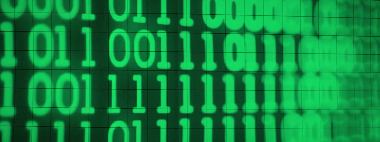 Bright green binary code changing on a dark gridded screen