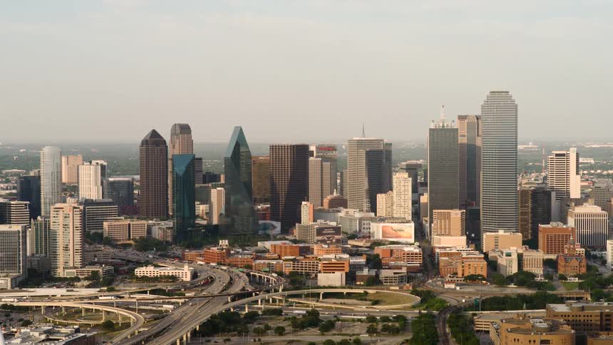 A large city with a bridge highways full of cars and tall buildings