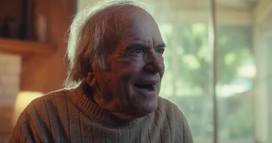 An old man takes off a virtual reality headset and looks happy