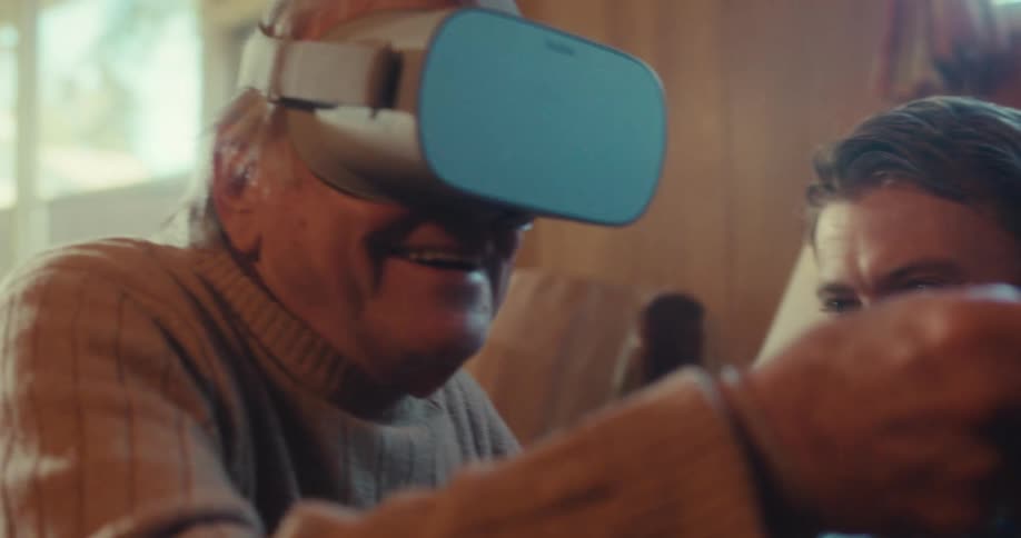 A man talks with another man using a virtual reality headset