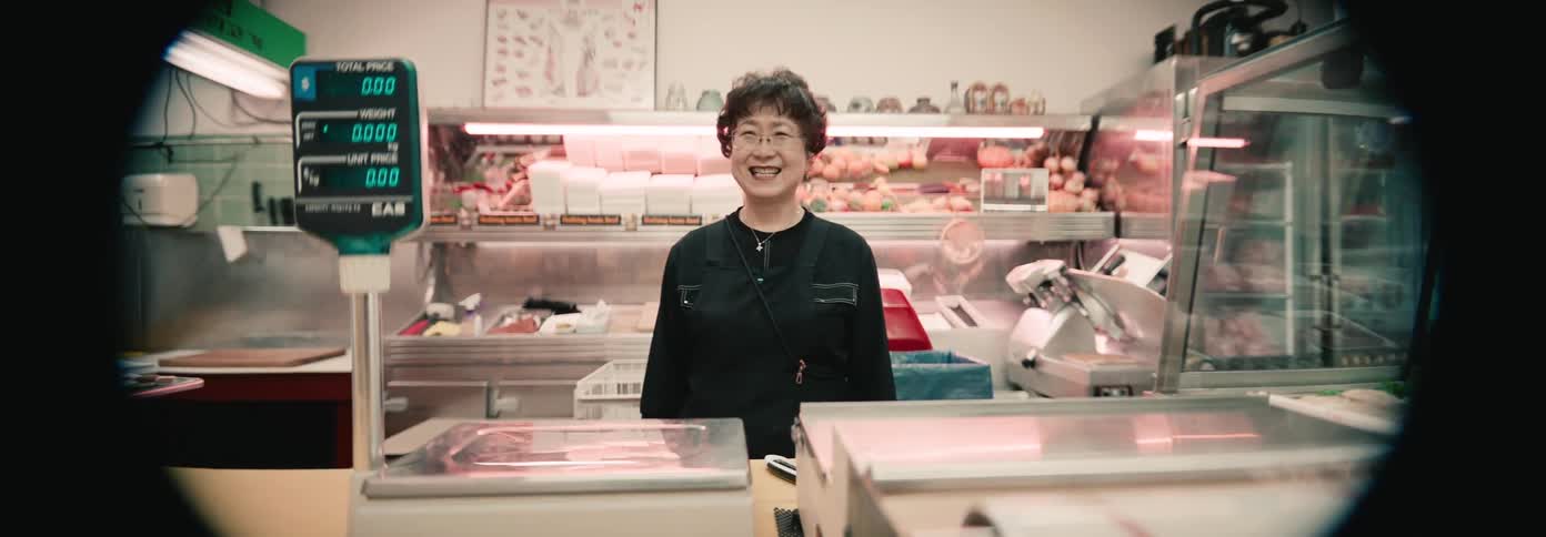 A woman stands behind the scale in the butcher shop