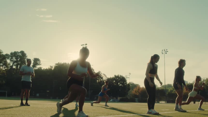 A group of people workout together on the field